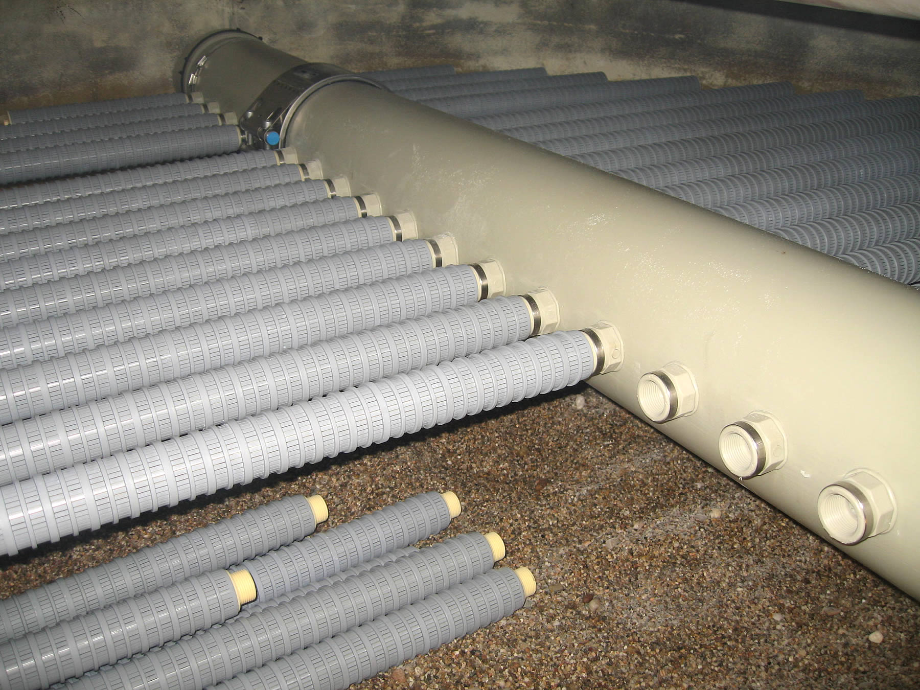 Filteranlage mit grauen Kunststoff-Filtern im Kiesbett &ndash; moderne Wasseraufbereitung f&uuml;r Schwimmb&auml;der und Anlagenbau.