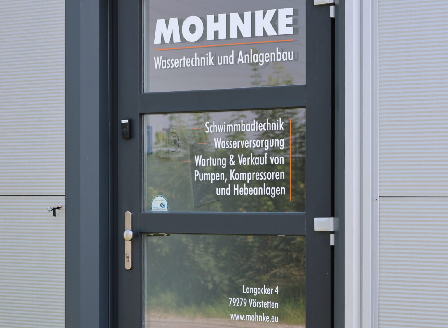 Eingangst&uuml;r von MOHNKE Wassertechnik und Anlagenbau in V&ouml;rstetten mit Firmenlogo und Leistungs&uuml;bersicht